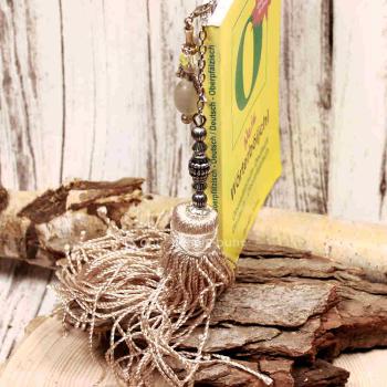 Handgefertigter Bookmarker von chic-peppig-bunt steckt in gelbem Buch.